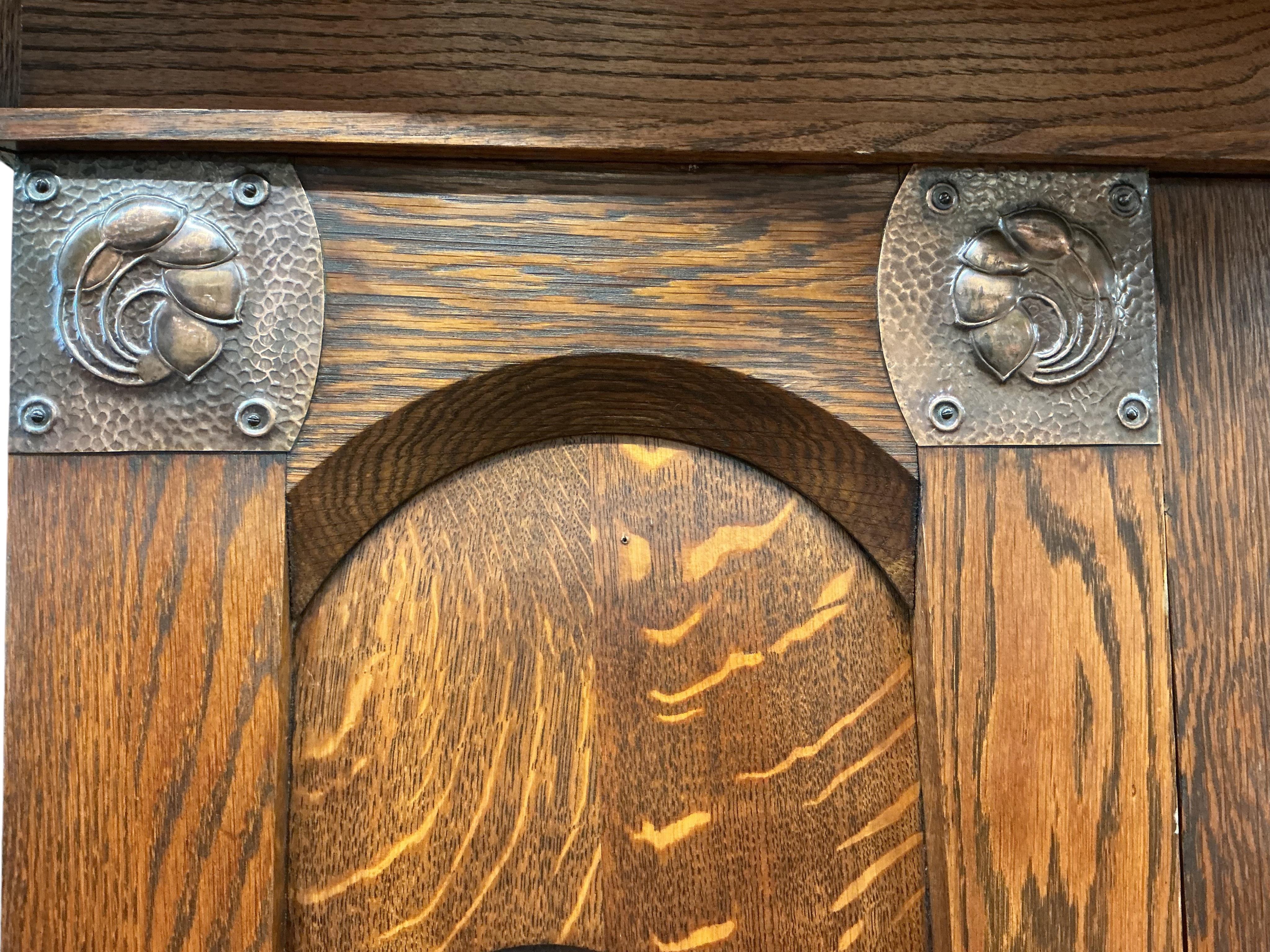 An Arts and Crafts copper mounted oak wardrobe in the manner of Shapland & Petter, width 176cm, depth 65cm, height 209cm